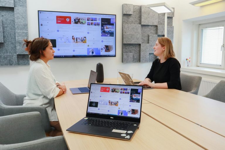 Professional training session with diverse adults around laptops and AI interface mockups, modern bright classroom, focused learning atmosphere, natural lighting, 'professional retraining' keyword — Formations 90